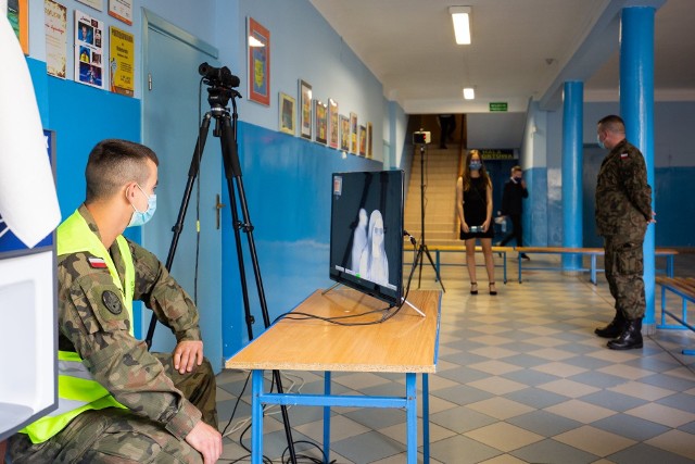 Żołnierze Obrony Terytorialnej z Grójca przy użyciu nowoczesnego urządzenia sprawdzali czy uczniowie wchodzący na egzamin nie mają podwyższonej temperatury ciała. Tu podczas działań w grójeckiej Publicznej Szkole Podstawowej numer 2.