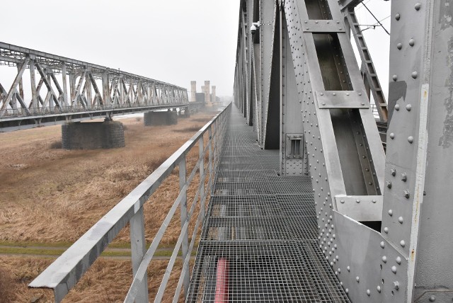 Pomosty techniczne wzdłuż torów na moście kolejowym na Wiśle są ażurowe i dość wąskie. Dlatego kolej uznaje je za niebezpieczne