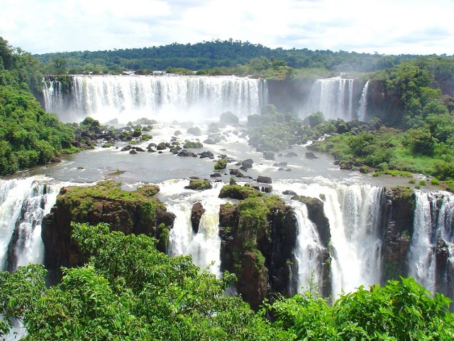 Na granicy Brazylii i Argentyny znajdziemy jeden z największych i najbardziej spektakularnych wodospadów na świecie. Niagara to przy nim jedynie niewielki strumień.Powstałe 150 mln lat temu wodospady na rzece Iguaçu mają wysokość do 80 metrów. Ich szerokość po stronie po brazylijskiej 800 metrów, a argentyńskiej aż 1900 metrów! Strona Brazylii oferuje za to najlepsze panoramiczne widoki i dostęp do „Gardła Diabła” – długiej przepaści o wysokości 82 metrów, wyróżniającej się kształtem litery U.Ponad wodospadem, znajduje się długi most, który pozwala na obserwowanie kilku kaskad. Podczas korzystania z tej atrakcji można trochę zmoknąć, ale warto – to z pewnością nie jest codzienny widok.– Równie niesamowite jak sam Iguazú jest jego otoczenie. Jeżeli będziemy mieli oczy otwarte, być może uda nam się zobaczyć wyjce, jaguara, tukany i inne wspaniałe, kolorowe ptaki. Warto też wybrać się na stronę argentyńską i skorzystać z przejażdżki łodzią pod wodospadem – mówi Piotr Wilk z biura podróży Rainbow. Źródło: r.pl