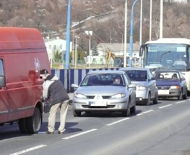 Kierowca samochodu dostawczego na środku mostu w Sandomierzu nalewa paliwo do baku.