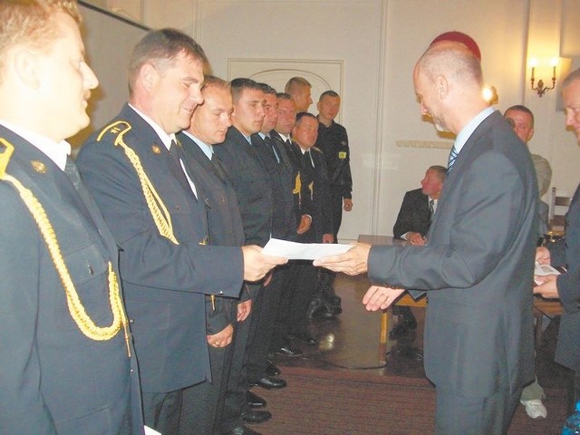 Starosta Krzysztof Bagiński (z prawej) wręcza białogardzkim strażakom nagrody. 