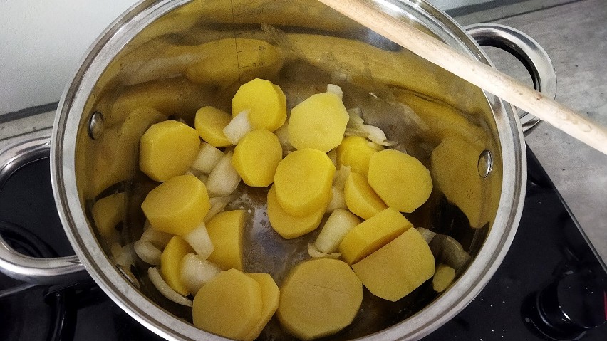 Pokrój ziemniaki i podsmaż jeszcze chwilę z cebulką.