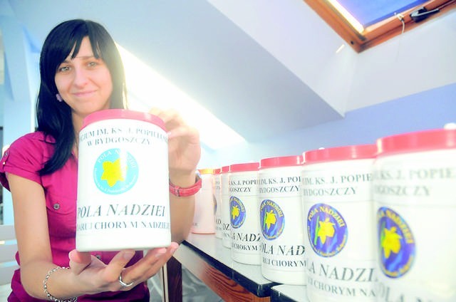 Agnieszka Maraśkiewicz z puszkami, które będą mieć wolontariusze