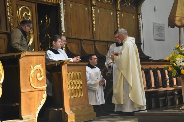 Przed przyjęciem komunii świętej należy odsłonić twarz, nie dotykając zewnętrznej części maski.