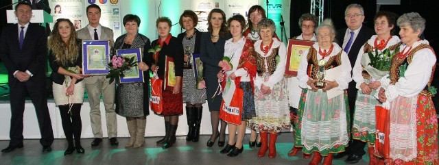 Laureaci konkursów w powiecie sandomierskim z wręczającymi od lewej: Grzegorz Świercz, wicemarszałek województwa świętokrzyskiego, Monika Iskierka i Marceli Małkiewicz z gospodarstwa agroturystycznego Winnica Sandomierska, Halina Wojtas z Wojtasówki, przedstawicielka Koła Gospodyń Wiejskich w Sośniczanach, Alicja Stępień - reprezentująca Gościniec Koćmierzów,  posłanka Platformy Obywatelskiej Marzena Okła &#8211; Drewnowicz oraz przedstawicielki Kół Gospodyń Wiejskich w Grabinie i Kleczanowie z europosłem Czesławem Siekierskim.