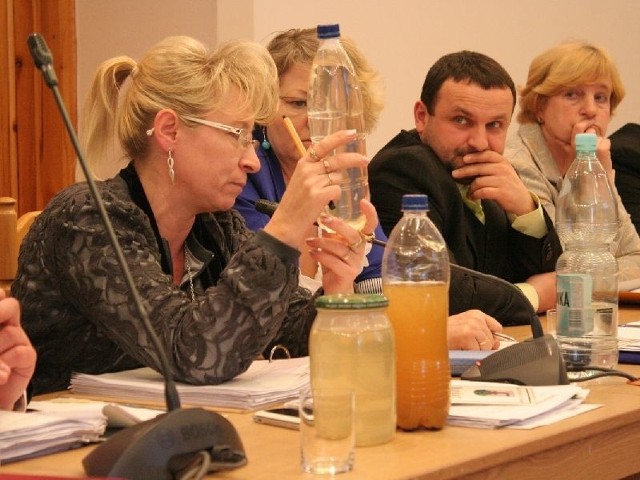 Radna Anna Stępień prezentuje butelki z wodą od mieszkańców.