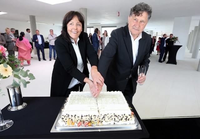 Beata Strojny i  Jerzy Strojny na otwarciu kroją tort, na którym widać symbol Storrady Park Offices