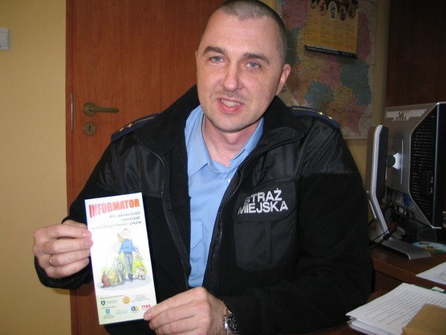Robert Kędziora, po. komendanta Straży Miejskiej w Tarnobrzegu pokazuje informator dla właścicieli zwierząt, w szczególności psów, jaki w ostatnich dniach został dostarczony mieszkańcom.
