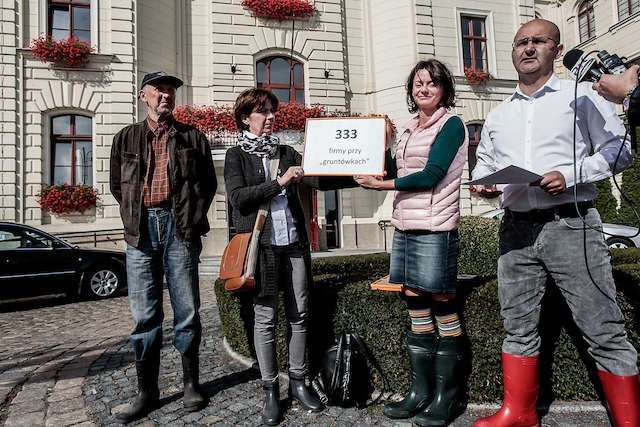 Społecznicy ze Stowarzyszenia Miedzyń-Prądy walczą o budowę dróg, stając pod ratuszem w... gumiakach.