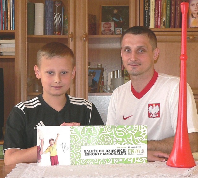 Buski supereskorter na Euro 2012 - Adaś Pałys (na zdjęciu z tatą Andrzejem) prezentuje certyfikat Dziecięcej Eskorty Mc Donald's z autografem Kuby Błaszczykowskiego.