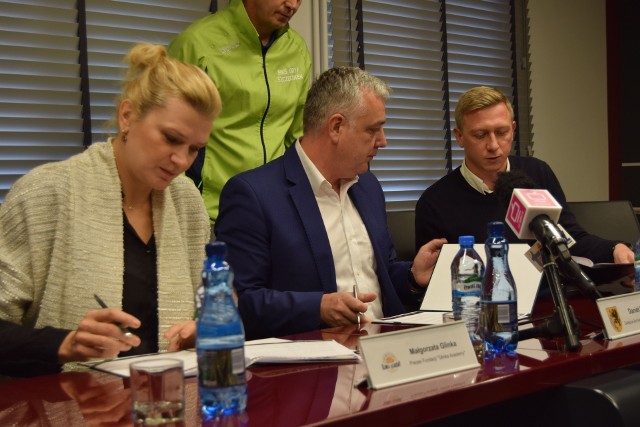 Małgorzata Glinka podpisuje umowę, w środku wiceburmistrz Daniel Rak, Maciej Makselon, dyrektor OSiR