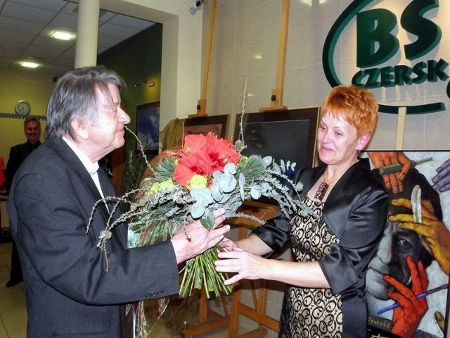 wręcza kwiaty Januszowi Trzebiatowskiemu podczas wernisażu w filii Banku Spółdzielczego
