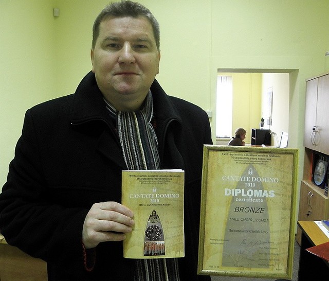Dyrygent chóru "Echo" Jerzy Cieślak prezentuje dyplom zdobyty w Kownie