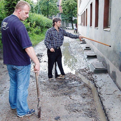 Po ostatnich obfitych opadach mieszańcy kamienicy przy Armii Krajowej walczą z wodą zalewającą ich posesję.