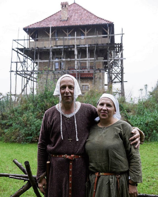 Wojciech Maniak z żoną Andrzeliką w średniowiecznych strojach na tle wzniesionej już wieży. – Chcemy coś po sobie zostawić, żeby dzieci mogły uczyć się historii – mówią mieszkańcy Tarnowa