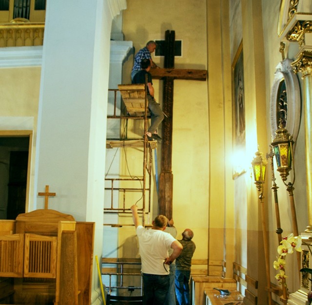 Montaż zabytkowego krzyża w nawie bocznej mirzeckiego kościoła