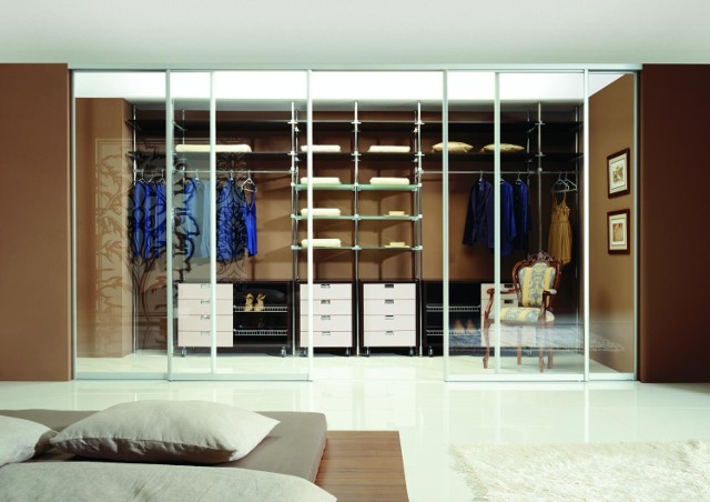 Garderoba z przeszklonymi drzwiamiFragment pomieszczenia odcięty szklanymi drzwiami pełni rolę funkcjonalnej garderoby. Optycznie zachowuje wrażenie przestrzeni.