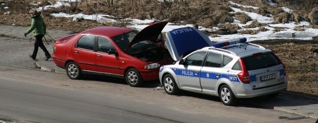 Policjanci pomagają kierowcy naładować akumulator w samochodzie