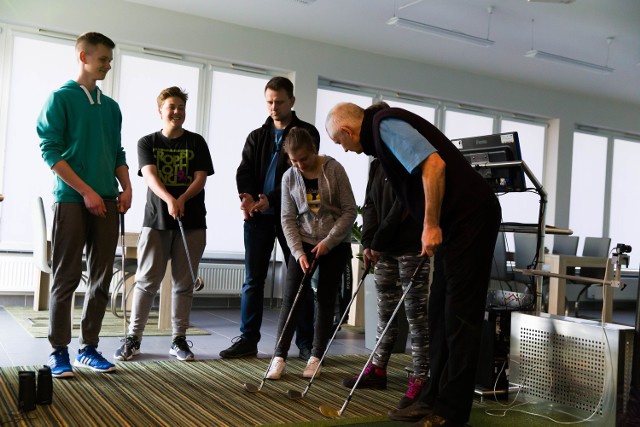 Bernard Wydra z Golfstoku demonstruje młodzieży X LO golfowe uderzenia