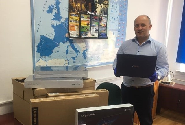 Burmistrz Osieka - Rafał Łysiak, prezentuje zakupione przez gminę laptopy.