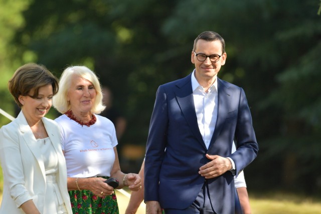 Premier Mateusz Morawiecki oraz minister rodziny i polityki społecznej Marlena Maląg podczas spotkania z seniorami w Zespole Szkolnym w Siennicy