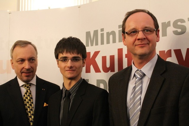 Piotr Zarzyka -w środku - podczaa uroczystosci - z lewej minister Bogdan Zdrojewski, z prawej Robert Pluta, dyrektor Zespołu Szkół Muzycznych.