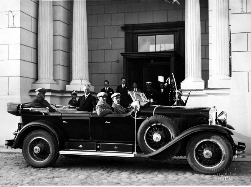 Józef Piłsudski siedzi w samochodzie, obok auta stoi...
