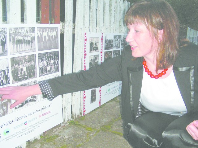 Bogusława Gawryluk, współautorka projektu "Dubicka historia na płocie pisana&#8221;, na tle wystawy.