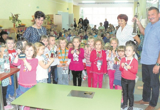           Dzieciaki na pamiątkowym zdjęciu z medalami zdobytymi przez Jacka Łabudzkiego (z prawej). 