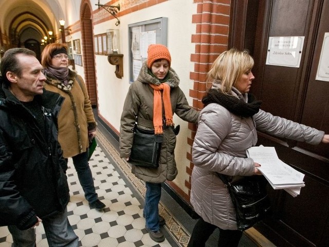 Rodzice i nauczyciele z Gimnazjum nr 1 z uchwałą obywatelską wchodzą do biura rady miejskiej w ratuszu. 