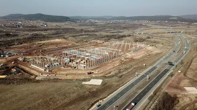 Wielka inwestycja w Chęcinach w powiecie kieleckim już się rozpoczęła. To budowa wielkiego centrum logistycznego 7R Park Kielce. Centrum będzie zajmować się wynajmem powierzchni magazynowych dla firm. Realizacja może kosztować 100 milionów złotych. Zatrudnienie znajdzie tam kilkaset osób. Nowo budowana inwestycja ma mieć powierzchnię około 60 tysięcy metrów kwadratowych. Przypomnijmy, że działka, na której planowane jest Centrum Logistyczne, należała wcześniej do Poczty Polskiej, która przed laty chciała w tym miejscu wybudować węzeł ekspedycyjno - rozdzielczy. Plany jednak zmieniono, a działka była nieużytkowana przez kolejne lata, aż do tej pory. Budynki będą dostosowane zarówno do potrzeb rozwijających się firm, które chciałyby wynająć powierzchnię od 1500 metrów kwadratowych, jak i wielkich przedsiębiorstw. Takich, które chcą mieć dużą bazę dystrybucyjną. W centrum będzie też możliwe prowadzenie lekkiej produkcji. Kluczowym partnerem całej inwestycji jest kielecka firma Polonez Plus. Dostarczenie pierwszej fazy inwestycji, to jest 24,5 tysiąca metrów kwadratowych, planowane jest na 1 czerwca 2019 roku. Najem powierzchni już trwa. 