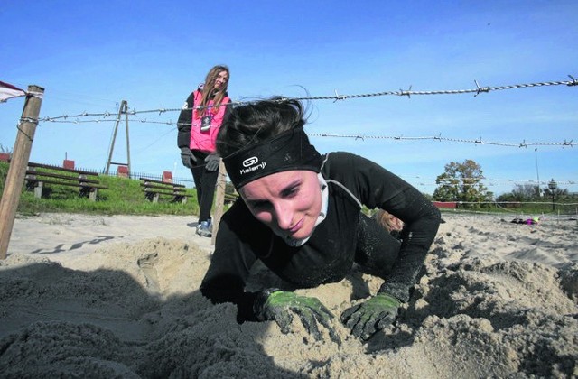 Czołganie się po piachu pod zasiekami z drutów kolczastych to jedna z łatwiejszych przeszkód na trasie biegu Mud Max. 