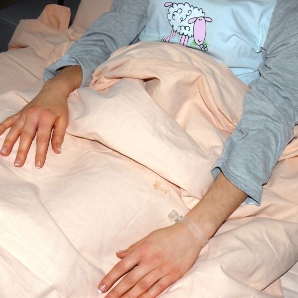 Poparzona petardą młoda kobieta na szpitalnym łóżku.