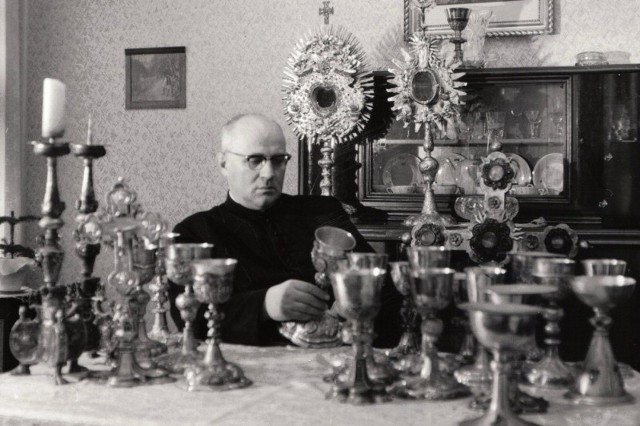 Ksiądz prałat Józef Kądziołka wraz z odnalezionymi pod posadzką prezbiterium naczyniami liturgicznymi.