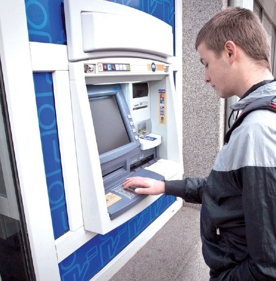 Pan Karol pobiera pieniądze z bankomatu Euronetu na Starym Rynku. Urządzenie jest już ciche.