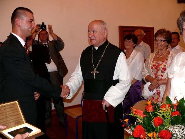 Ksiądz opat Eustachy Kocik przyjmuje tytuł honorowego mieszkańca Wąchocka z rąk przewodniczącego Rady, Sebastiana Staniszewskiego.