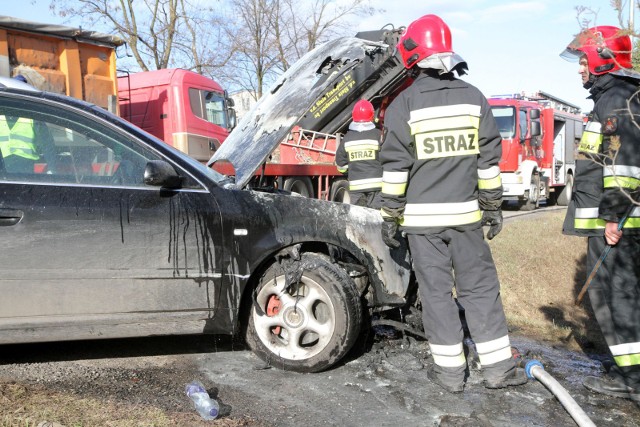 Strażacy kończą gaszenie pożaru, który trawi samochód zaparkowany w Bydgoszczy. 