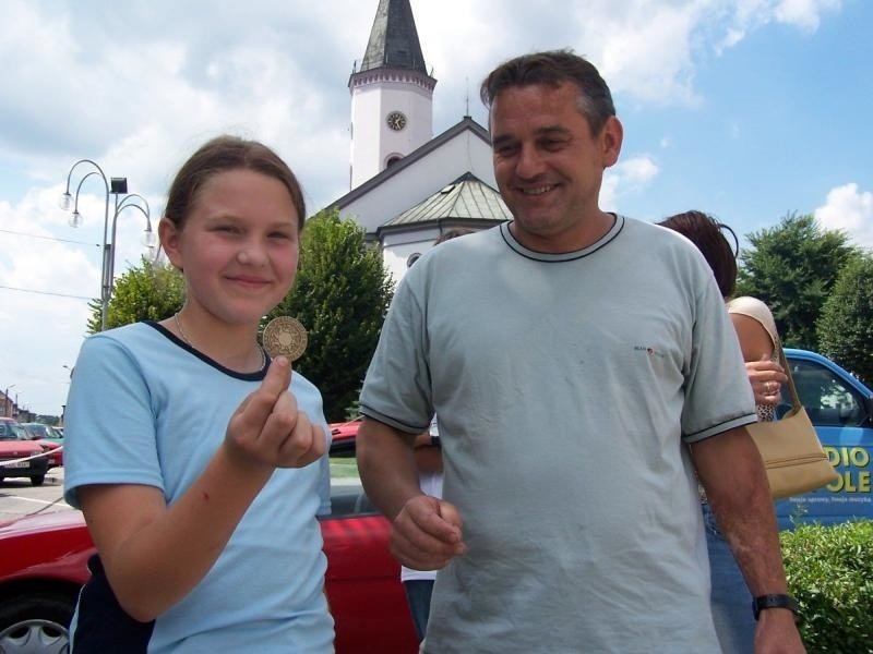 Kasia Nowak pokazuje znalezioną monetę. Obok tata Roland,...