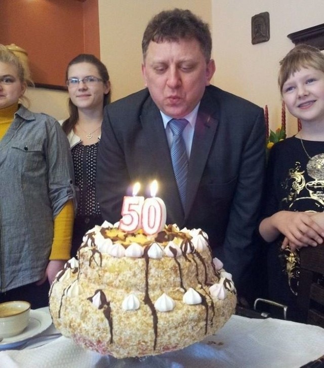 Wojciech Furmanek zdmuchuje świeczki na urodzinowym torcie