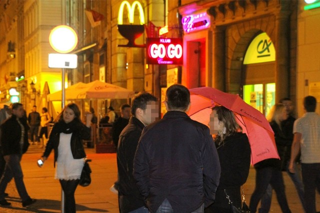 Promotorki z różowymi parasolkami zapraszają na wrocławskim Rynku do odwiedzenia klubu Go Go