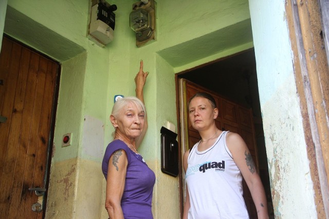 Barbara Górna i jej córka Katarzyna pokazują, że za licznikiem energii elektrycznej pali się instalacja.