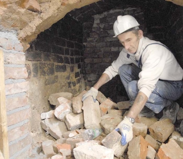 Mieczysław Mierzejewski wyciąga cegły z odkrytego, zabytkowego paleniska. Zdaniem specjalistów, to bardzo ważne znalezisko.