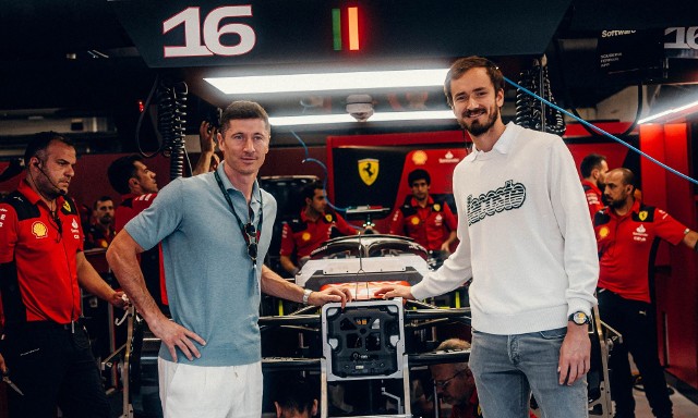 Robert Lewandowski pozuje do zdjęcia z Daniiłem Miedwiediewem przy bolidzie Ferrari w padoku Formuły 1 podczas Grand Prix Hiszpanii