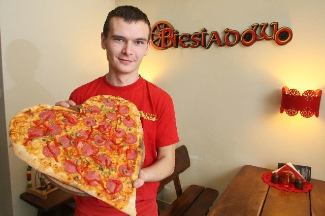 Pizza w kształcie serca z czerwonymi dodatkami to ciekawy pomysł na walentynkowy posiłek.