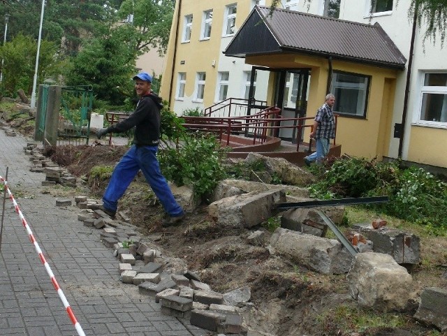 Rozbiórka płotu przy szkole i usuwanie wyciętych krzewów, wkrótce stanie nowy płot z prętów.