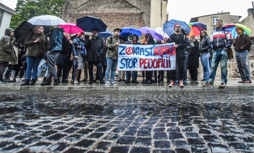 Protestujący stali w strugach deszczu, trzymali transparent...