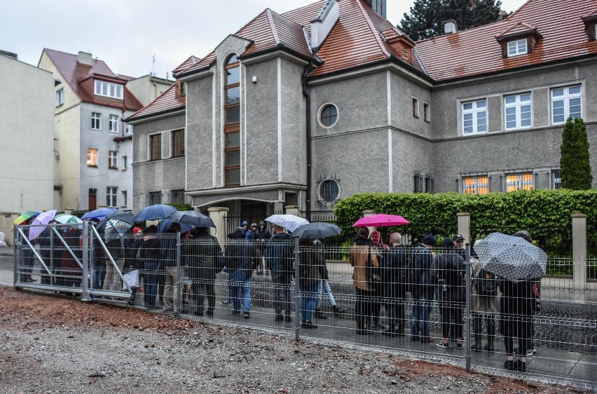 Protestujący stali w strugach deszczu, trzymali transparent...