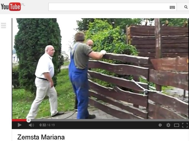 Kadr z nagrania, na którym widać burmistrza Mariana Tołodzieckiego, pokazującego,  gdzie należy ciąć bramę