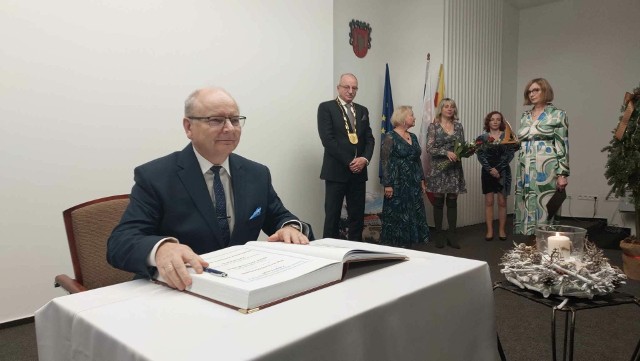 Burmistrz Końskich Krzysztof Obratański wpisuje się do pamiątkowej księgi