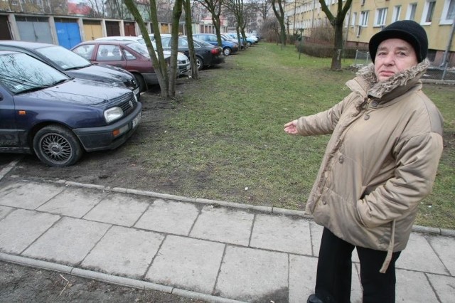 Ewa Romaniec-Nowacka z ulicy Mazurskiej 64 w Kielcach pokazuje, że auta parkują wzdłuż całego bloku w miejscu, gdzie jest trawnik.